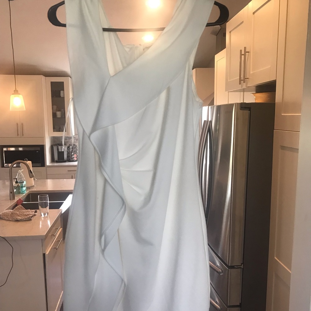 White sleeveless, asymmetrical dress with a slit